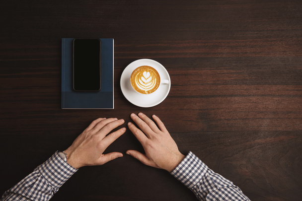 Businessman hands near cup of cappuccino  - Φωτογραφία, εικόνα