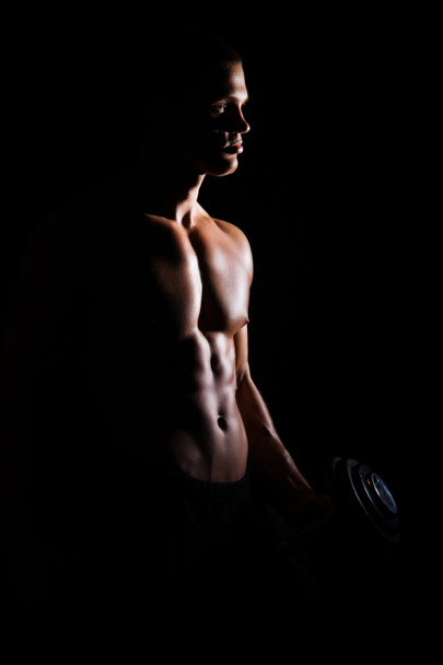 Bodybuilder man with a dumbbell - Фото, изображение