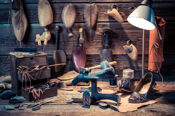 Vintage shoemaker workshop with shoes, laces and tools - Foto, imagen