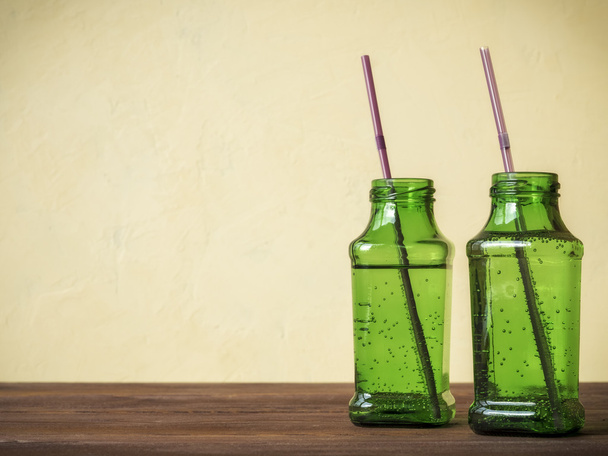 Green bottles on wooden table - Photo, Image