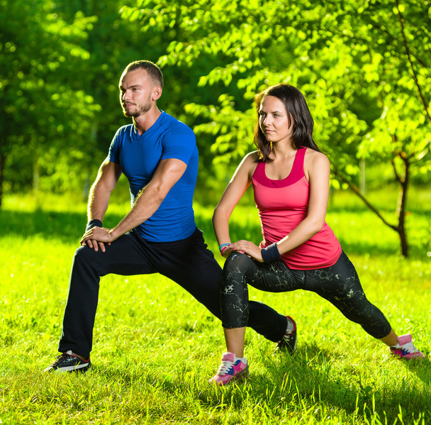 Man and woman doing stretching exercises - Foto, afbeelding