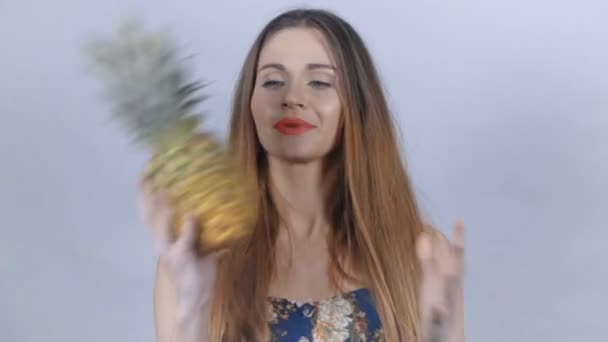 Mladá sexy dívka s červenými rty se baví s ananasem. - Záběry, video
