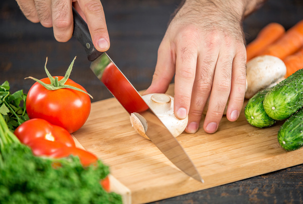 Mies kädet leikkaamalla vihanneksia salaattia
 - Valokuva, kuva