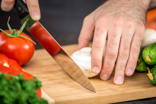 Мужские руки режут овощи для салата
 - Фото, изображение