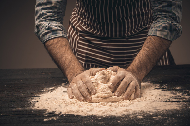 Male hands knead the dough. - Foto, afbeelding