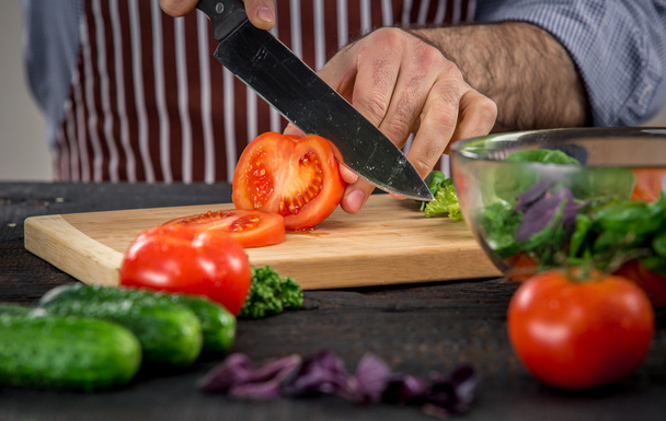 Manos masculinas cortando verduras para ensalada
 - Foto, imagen