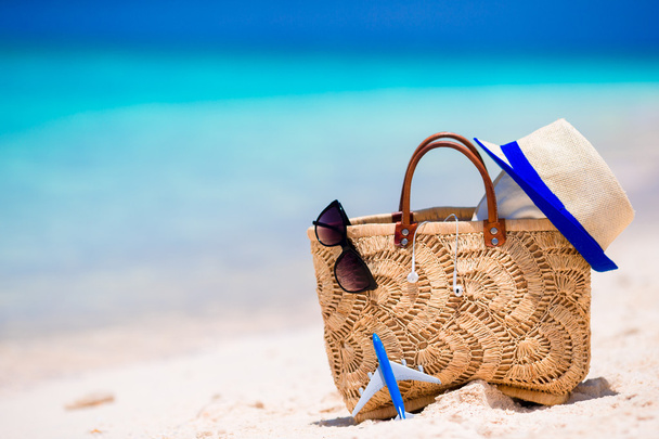 Praia consept - saco de palha, chapéu, óculos de sol e toalha na praia branca
 - Foto, Imagem