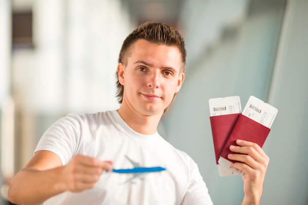 Young man with small airplane in airport waiting his flight - Photo, Image