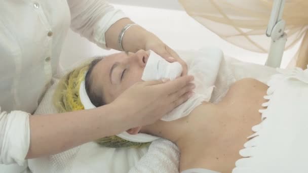 esteticista profesional poner servilletas en la cara de la mujer para mojarse en el salón. Cáscara
 - Imágenes, Vídeo