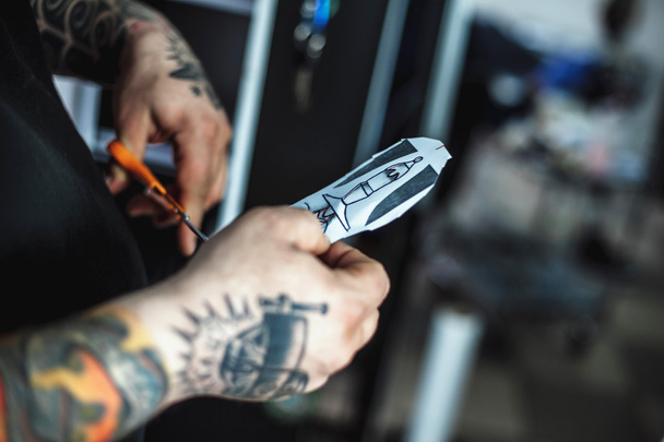 Male tattoo artist shows a sketch - Фото, изображение