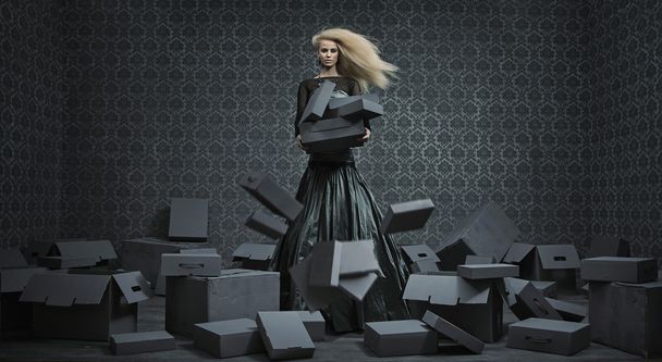 Conceptual picture of a blond lady among a lot of boxes - 写真・画像