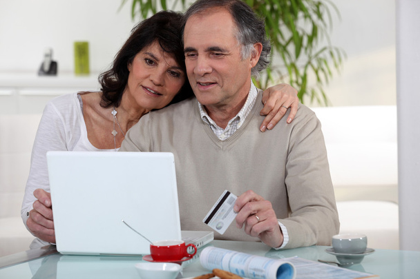 Middle-aged couple shopping on-line - Foto, Bild