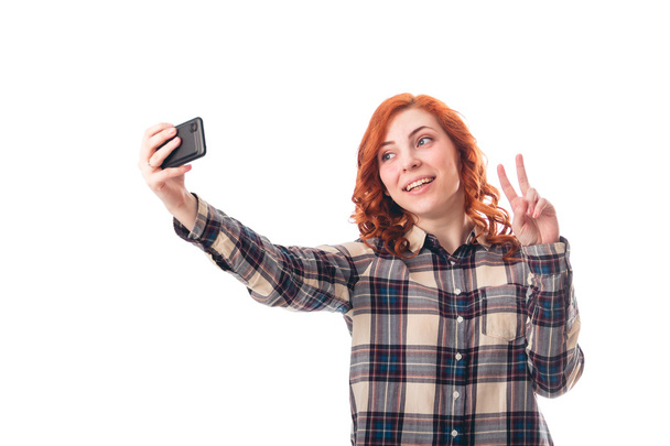 Portrait of a young woman making selfie photo on smartphone - Foto, afbeelding