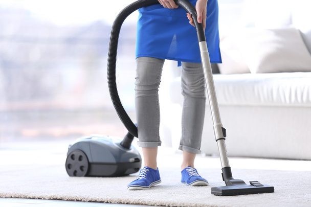 Cleaning concept. Young woman cleaning carpet with vacuum cleaner, close up - Foto, immagini