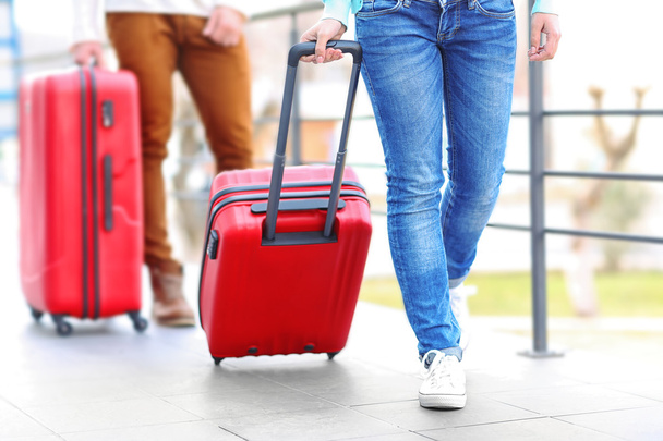 Couple rolling red suitcases - 写真・画像