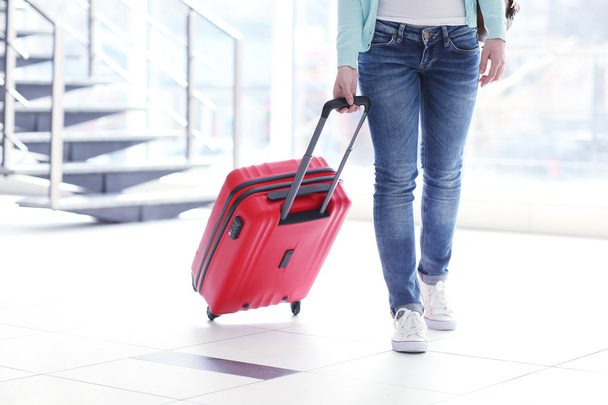 Woman rolling a red suitcase - Zdjęcie, obraz