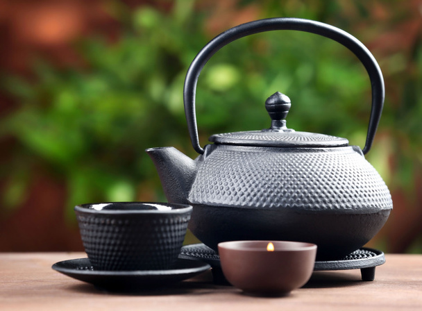 Black pialats and teapot on blurred background - Photo, Image