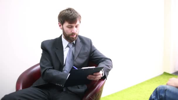 Male psychiatrist with pencil and clipboard - Materiał filmowy, wideo