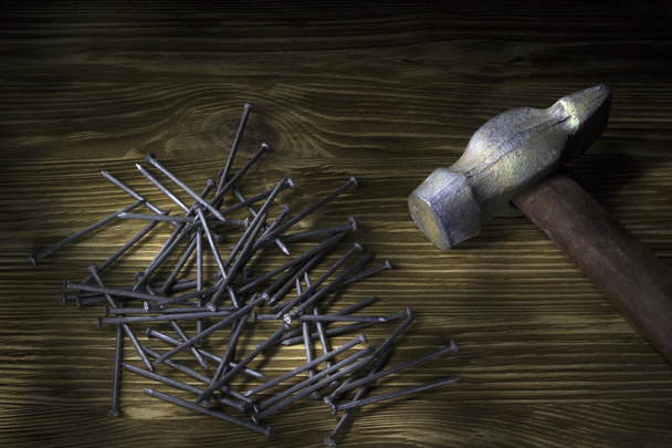 Молот і цвяхи на дерев'яному столі
 - Фото, зображення