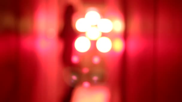 Silueta de una mujer sexy en tacones altos bailando y acercándose en un borroso corredor rojo
. - Metraje, vídeo