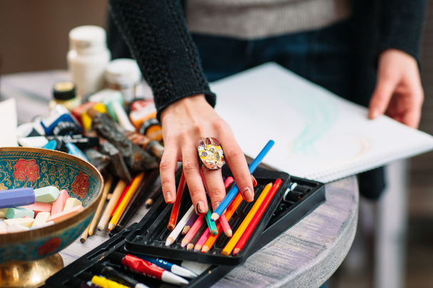 Painter artist chooses a color pencil. Closeup - Foto, afbeelding