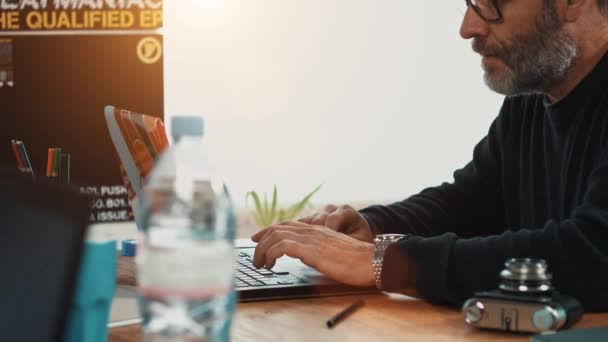 Liikemies työskentelee kannettavan tietokoneen kanssa toimistossaan
 - Materiaali, video
