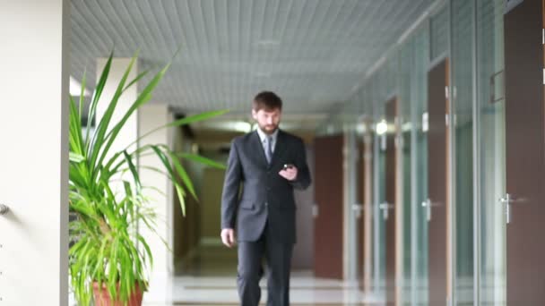 successful business man having cell telephone conversation while standing in office interior, - Video
