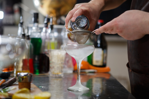 Бармен готовит коктейль за барной стойкой
 - Фото, изображение