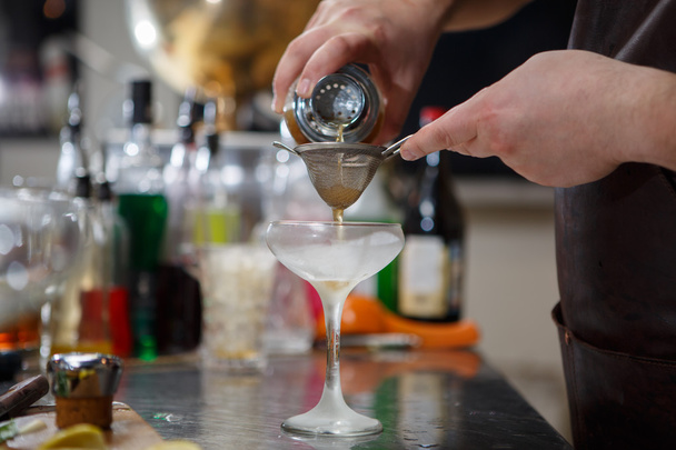 Бармен готує коктейль за барною стійкою
 - Фото, зображення