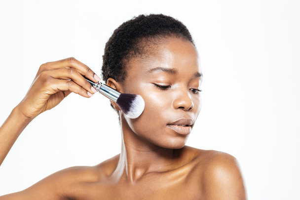 Afro american woman applying makeup with brush - Fotoğraf, Görsel