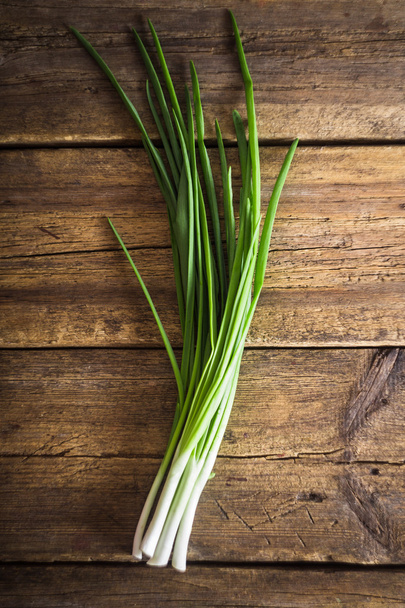 Green onions on wooden background. Cooking - Photo, Image