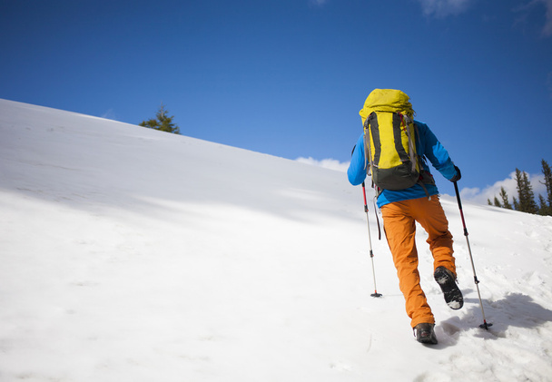 Bergsteiger mit Rucksack erklimmt den Schnee. - Foto, Bild
