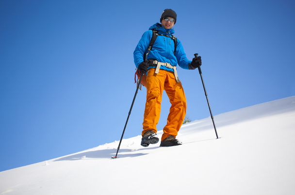 Der Bergsteiger geht auf den Schneehang. - Foto, Bild