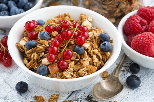 homemade muesli and fresh berries on white wooden background - Foto, afbeelding