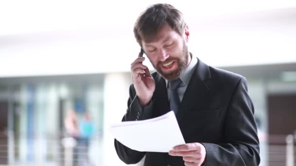 Mature Businessman Working With Papers And Cellphone At Workplace - Video, Çekim