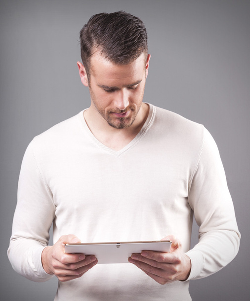 Handsome man holding a digital tablet - Foto, afbeelding