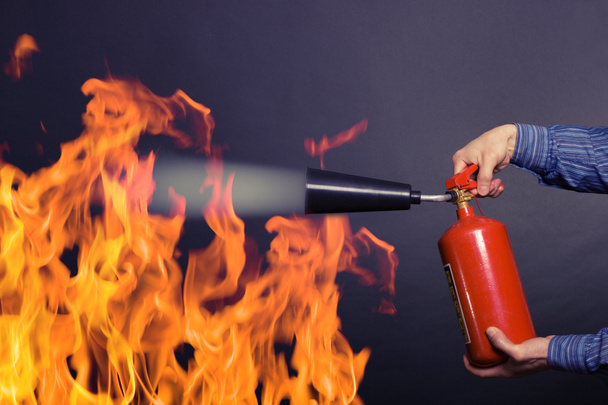 Homem com extintor a combater um incêndio
 - Foto, Imagem