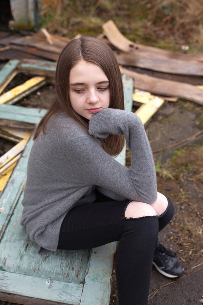 Muito jovem adolescente sentada em algumas portas antigas
  - Foto, Imagem
