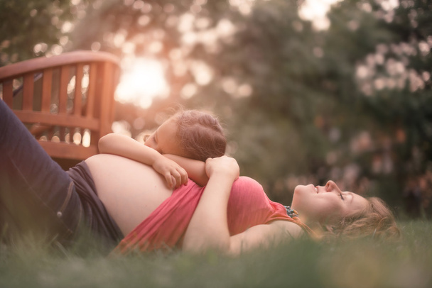 Беременная мать и дочь ждут новорожденного брата
 - Фото, изображение