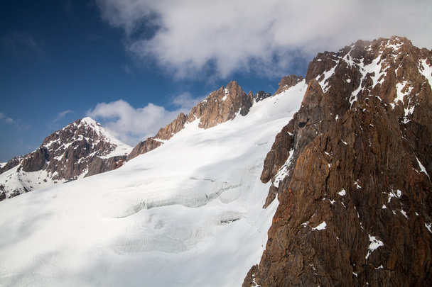 Snowy glacier and rock wall in Tian Shan mountains - Photo, image