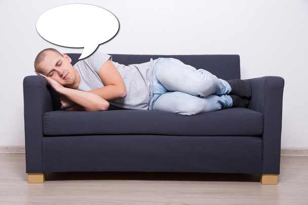 hombre durmiendo en el sofá en casa y soñar con algo - Foto, imagen
