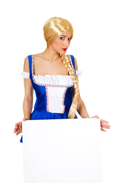 Woman wearing Bavarian dress holding empty banner. - Φωτογραφία, εικόνα