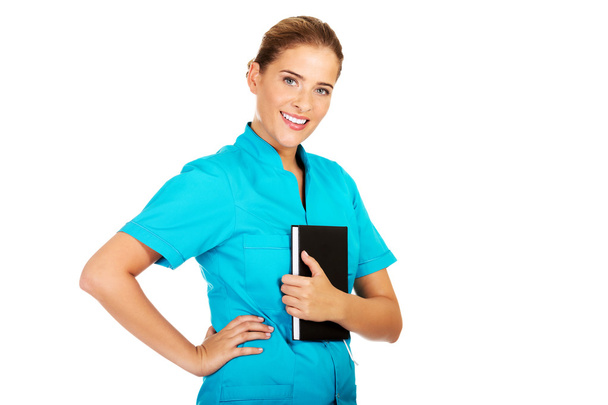 Young female doctor or nurse holding black notes - Valokuva, kuva