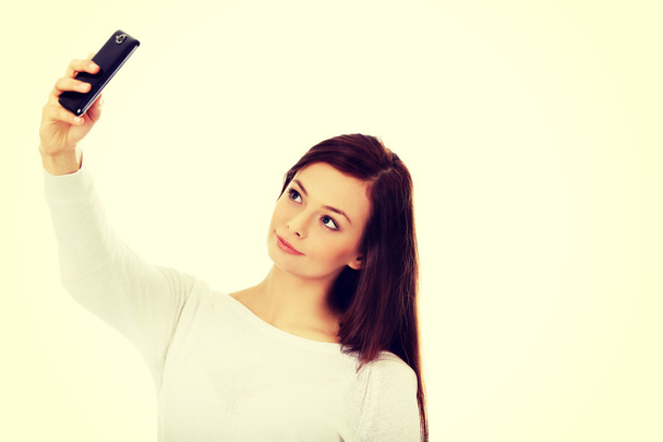 Happy young woman makes selfies with smart phone - Foto, Imagem