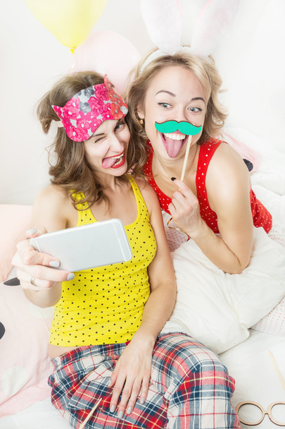 Adorable two happy woman having fun using mobile phone. - Photo, Image
