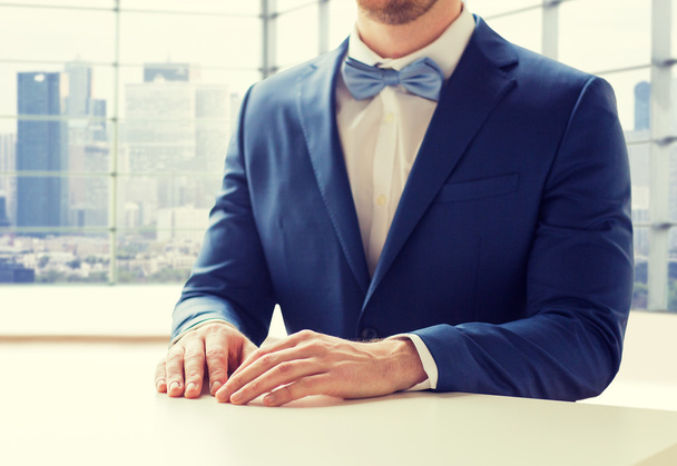 close up of man in suit and bow-tie at table - Foto, imagen