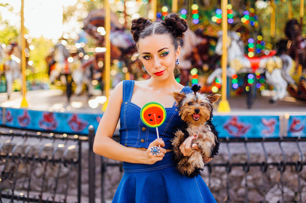 Bright makeup beautiful girl with Yorkshire Terrier holding watermelon lollipop.  - Foto, Imagen