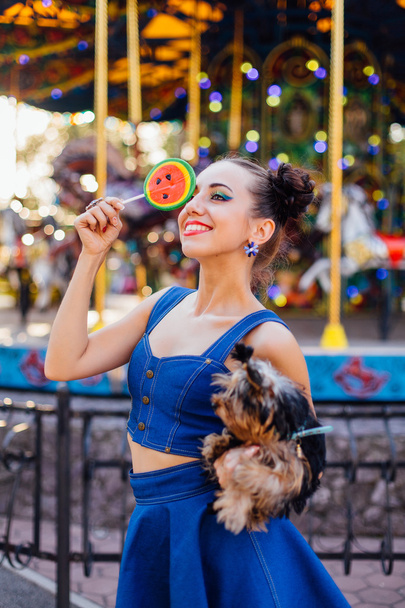 Bright makeup beautiful girl with Yorkshire Terrier holding watermelon lollipop.  - Fotoğraf, Görsel