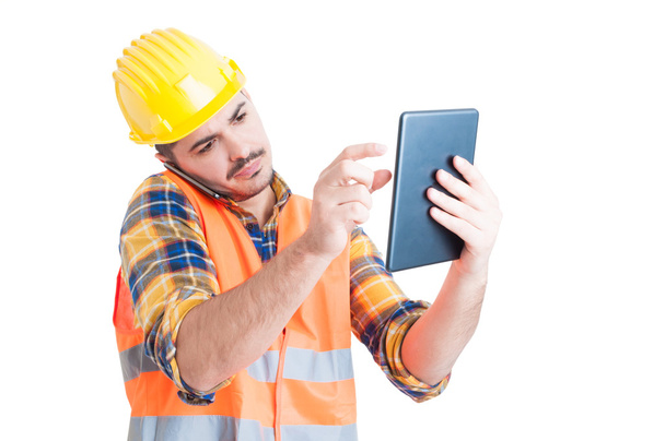 Ingeniero guapo hablando por teléfono y sosteniendo una tableta
 - Foto, imagen