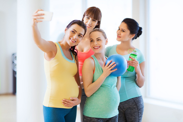 pregnant women taking selfie by smartphone in gym - Photo, Image